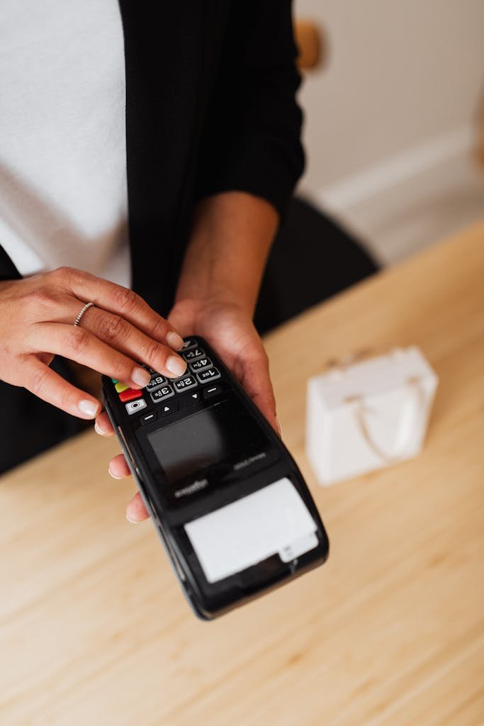 A person's hand using a card payment terminal, illustrating a cashless transaction.